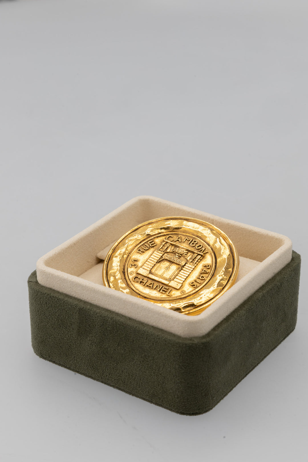 Broche médaillon CHANEL Vintage 31 Rue Cambon en métal doré