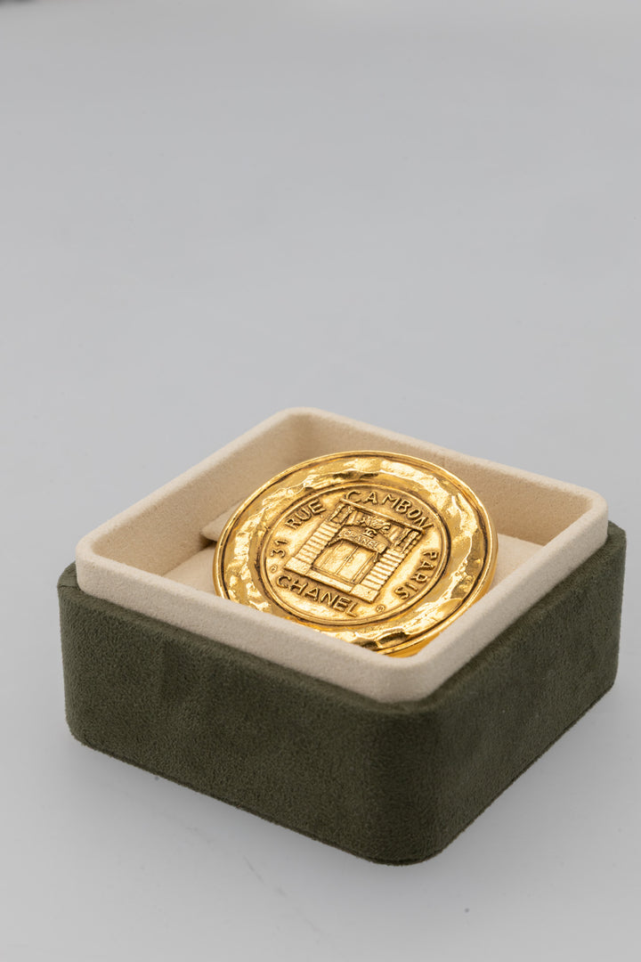 Broche médaillon CHANEL Vintage 31 Rue Cambon en métal doré
